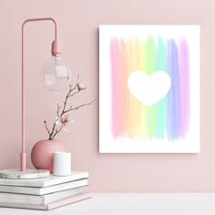 a pink wall with a white heart on it and some books next to the lamp