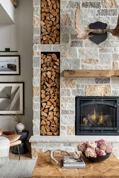 a living room filled with furniture and a fire place in front of a stone wall