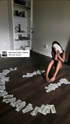 a woman sitting on the floor with money falling out of her mouth and hands in front of her face