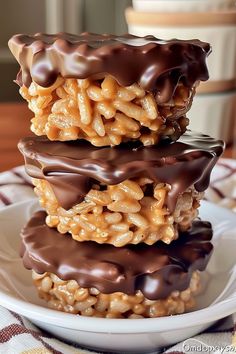 three chocolate covered pretzels stacked on top of each other in a white plate