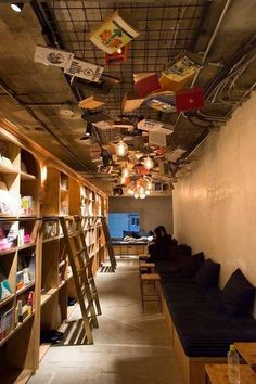 a long room with ladders hanging from the ceiling and bookshelves on the walls