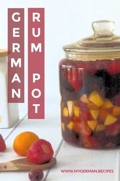 a jar filled with lots of fruit sitting on top of a counter next to a cutting board