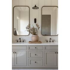 a bathroom with two sinks and mirrors on the wall