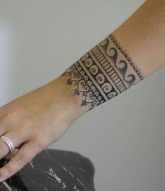 a woman's hand with a tattoo on her left wrist and the other arm