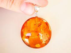 "Exquisite and completely eye-catching natural amber pendant made with sterling silver findings shines bright even the darkest day. This royal cognac color shiny amber pendant is shaped into a classic flat round form. And since amber is an exquisite resin that keeps warmth and the sense of genuineness, you can share this goodness with your loved one. MATERIALS AND SIZE: Stone: 100% Natural Baltic Amber Other materials: sterling silver 925 Weight: 11,1 g (0,39 oz) Pendant size: 3,3 cm (1,29 in) x Baltic Amber Round Pendant Necklace, Cognac Color, Amber Pendant, Natural Amber, Small Charms, Amber Beads, Amber Stone, Amber Jewelry, Dark Brown Leather