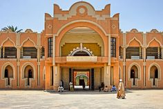 an old building with people standing outside it