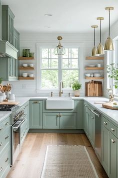 a kitchen filled with lots of green cabinets and white counter top space next to a window