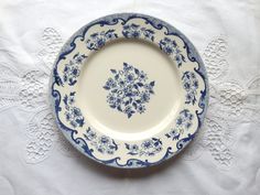 a blue and white plate sitting on top of a doily covered table cloth,