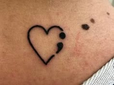 a woman's stomach with a heart and two dots on the bottom of it