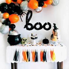 a table topped with balloons and halloween decorations