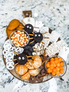 an assortment of halloween treats are arranged on a platter with candy and candies