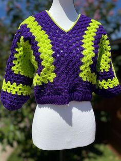 a white mannequin wearing a purple and yellow sweater