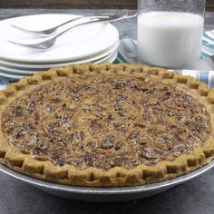 a pie sitting on top of a metal pan next to plates and milk jugs