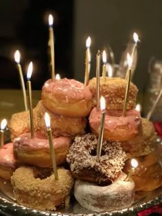 there are many donuts with candles in the middle of them on a platter