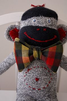 the sock monkey is wearing a bow tie