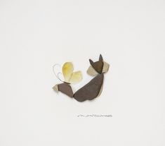 two birds made out of wood sitting next to each other on a white surface with writing underneath