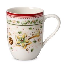 a white coffee cup decorated with holly and gingerbreads on the outside, red rim