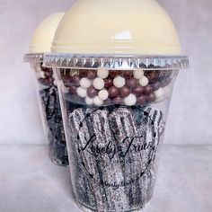 two plastic cups filled with chocolate covered candies