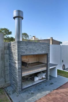 an outdoor fireplace with a grill on it