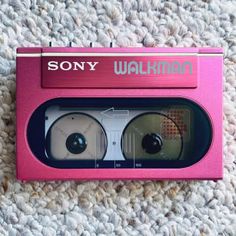 an old pink sony walkman is laying on the carpet