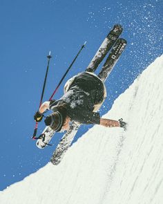 a man riding skis down the side of a snow covered slope