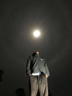 a man standing on top of a hill at night