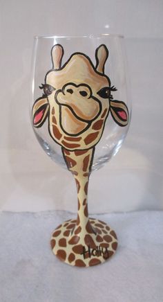 a wine glass with a giraffe painted on it's face and neck