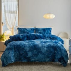 a bed with blue comforters and pillows in a room