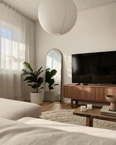 a living room with a large television on the wall and a mirror in the corner