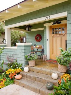 a house with flowers and plants on the front steps