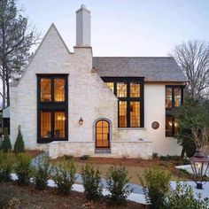 a white brick house with large windows and black shutters