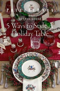 a christmas table setting with silverware and red placemats, holly wreath on the plate