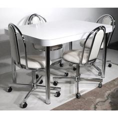 a white table with four chairs around it