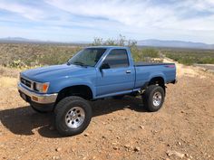 a blue pick up truck parked in the desert