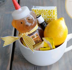 a cup filled with lemons, honey and other things to make it look like a bear