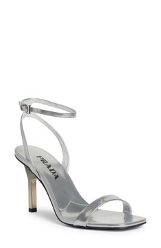 A sculptural heel with an iconic triangular Prada logo supports this minimalist ankle-strap sandal crafted of silvery calfskin leather. 3 1/4" (83mm) heel Adjustable strap with buckle closure Leather upper, lining and sole Made in Italy Designer Shoes Prada Women Shoes, Modern Silver Sandals With 4-inch Heel, Modern Metallic Ankle Strap Heels, Modern Silver Open Heel Sandals, Metallic Silver Heels With Ankle And Heel Straps, Metallic Ankle Strap Heels With Sculpted Heel, Luxury Silver Sandals With Sculpted Heel, Metallic Heels With Sculpted Ankle Strap, Metallic Heels With Sculpted Heel And Ankle Strap