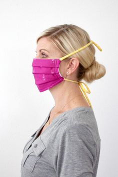 a woman wearing a pink mask with yellow straps around her neck and the bottom part of her face