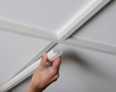 a person is painting the ceiling with white paint