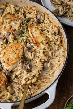 chicken and mushroom pasta in a skillet with a wooden spoon