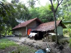 an old house with a satellite dish on top of it's roof in the woods