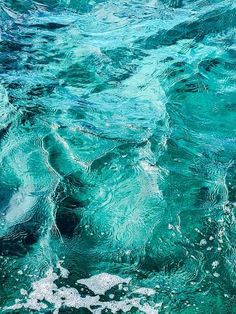 the water is very clear and blue with some white bubbles on it's surface