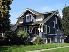 a blue house with white trim on the front and side windows is shown in this photo