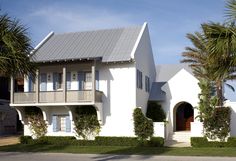 a white house with palm trees in front of it