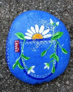 a painted rock sitting on top of a sidewalk