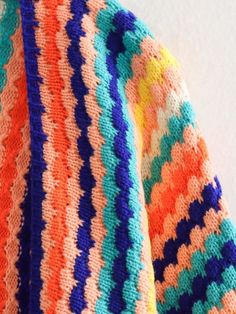 an orange, blue, and green striped knitted sweater