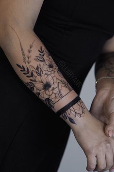 two people holding hands with tattoos on their arms