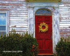 a red door with a yellow wreath on it