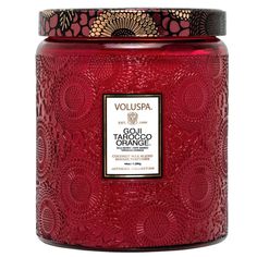 a red candle with an intricate design on it's lid and the words vouspa above it