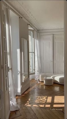 an empty room with wooden floors and white walls, large mirrors on the wall and floor