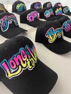 "one-of-a-kind custom-made black baseball hats! Choose one(1) Word and from up to (4) colors.  personalize with your name, town, city or brand.  since personalization is on a hat we have limited space for writing.  please personalize with one (1). Each hat is meticulously hand-painted, creating a truly unique and eye-catching effect.  With whimsical, curvy letters that add a touch of playfulness, every design is a work of art. What sets our hats apart is the dazzling embellishment of glitter, adding a touch of sparkle and personality. No two hats are exactly the same, making each piece a special and individual expression of style. Stand out from the crowd and showcase your own distinct flair with our hand-painted hats that are as unique as you are! please note: all hats will be made with g Custom Fitted Hats With Name On The Side, Customizable Black Custom Snapback Hat, Customizable Black Snapback Hat, Black Baseball Cap For Streetwear, Customizable Black Baseball Cap, Customizable Black Fitted Hat With Flat Bill, Custom Black Snapback Hat With Curved Brim, Custom Black Snapback Hat, Personalized Black Baseball Cap